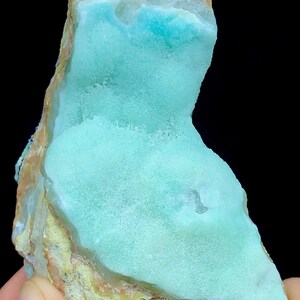 May include: A light blue and green, irregularly shaped, polished, natural stone with a rough, brown exterior.