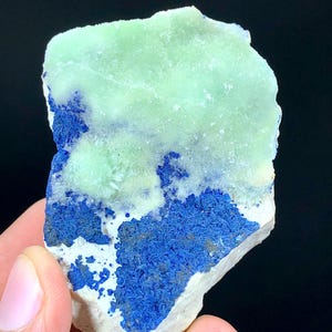 May include: A rough, natural specimen of green and blue mineral. The green mineral is a light, translucent green and the blue mineral is a deep, rich blue. The specimen is about the size of a hand.