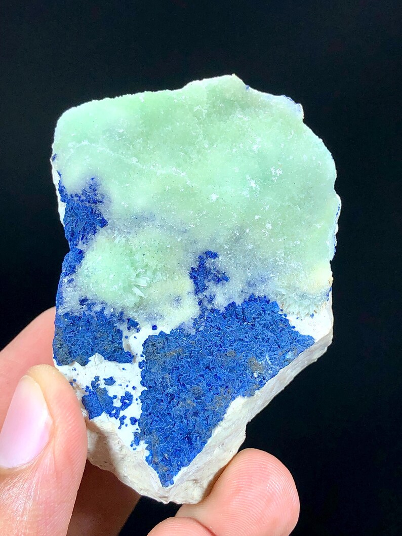 May include: A rough, natural specimen of green and blue mineral. The green mineral is a light, translucent green and the blue mineral is a deep, rich blue. The specimen is about the size of a hand.