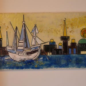 Könnte beinhalten: Ein rechteckiges Wandbild aus Keramikfliesen zeigt eine Küstenstadt mit einem großen weißen Segelschiff im Vordergrund, dunklen Gebäuden mit Kuppeln und Türmen, einer gelben Sonne und einem tiefblauen Meer in einem glänzenden, malerischen Stil.
