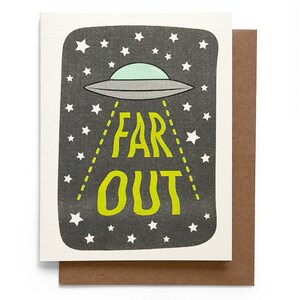May include: Greeting card with a black background featuring a grey UFO with a mint green top, surrounded by white stars. The words "FAR OUT" are in bright green. The card is paired with a brown envelope.