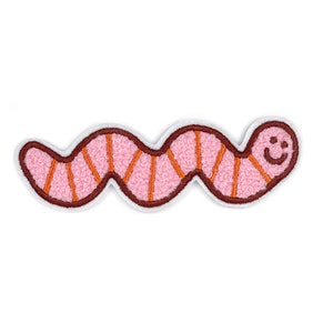 May include: A pink and orange embroidered worm with a smiling face. The worm is curled into a 'C' shape.