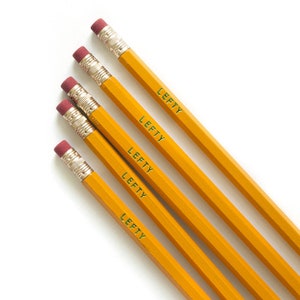 May include: Four yellow pencils with red erasers and the word "Lefty" printed on each pencil in green lettering.