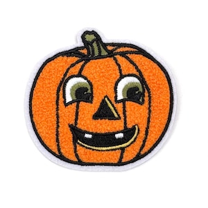 Peut inclure: Une citrouille orange souriante avec un visage noir et des yeux verts. La citrouille est brodée d'un contour blanc.
