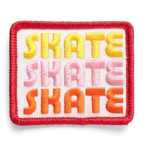 May include: A red embroidered patch with the word "SKATE" repeated three times in yellow, pink, and orange.