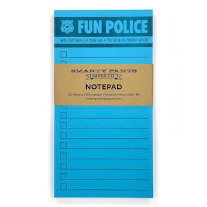 May include: A blue notepad with the words "FUN POLICE" printed at the top. The notepad has a brown paper band that reads "SMARTY PANTS PAPER CO." and "NOTEPAD". The notepad has lines and check boxes for making lists.