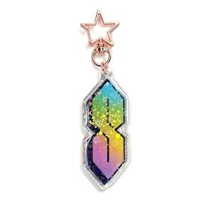 May include: A rainbow iridescent charm with a star-shaped keychain attachment. The charm features a stylized letter 'S' with a glittery background.
