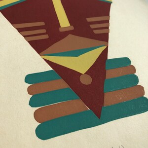 May include: A stylized geometric African mask with a red, brown, yellow, and teal color scheme. The mask is printed on a white background with the text "AFRICAN MASK (E.V.)" written below.