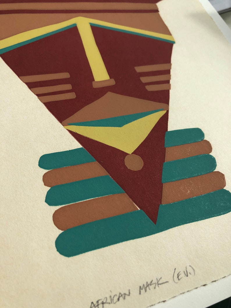 May include: A stylized geometric African mask with a red, brown, yellow, and teal color scheme. The mask is printed on a white background with the text "AFRICAN MASK (E.V.)" written below.