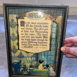Könnte beinhalten: Gerahmter Vintage-Druck mit dem Wort „HOME“ oben. Der Druck zeigt ein Gedicht über das Zuhause mit Illustrationen einer Familienszene. Der Rahmen ist dunkel mit aufwendigen Details.