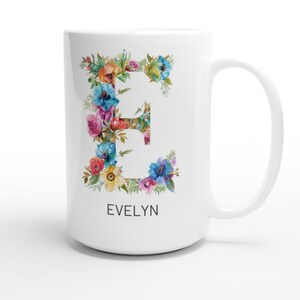 May include: White ceramic mug with a floral design featuring the letter "E" and the name "EVELYN" printed below. The flowers are in shades of pink, blue, yellow, and green.