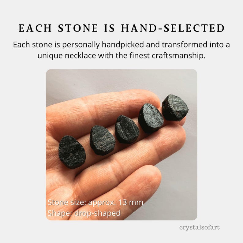 May include: The image displays five drop-shaped, black stones, each approximately 13 mm in size, resting on a hand. The text reads "EACH STONE IS HAND-SELECTED" and describes the stones as being handpicked and transformed into unique necklaces.