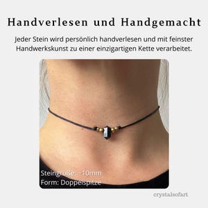 May include: A black choker necklace with a dark gemstone pendant and gold-colored beads. The necklace is displayed around a person's neck. Text on the image reads "Handverlesen und Handgemacht" and "Steingr&ouml;&szlig;e: ~10mm".
