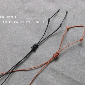 Puede incluir: Primer plano de dos cordones ajustables, uno negro y otro marr&oacute;n, con nudos. El texto "WATERPROOF EASY ADJUSTABLE IN LENGTH" est&aacute; en letras blancas en la parte superior. Los cordones est&aacute;n sobre una superficie gris.