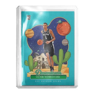 May include: A basketball trading card featuring Victor Wembanyama in a San Antonio Spurs uniform. The card has a colorful design with planets, cacti, and the Alamo. The word "Downtown" is displayed prominently.