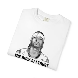 Könnte beinhalten: Ein weißes kurzärmeliges T-Shirt mit einer schwarz-weißen grafischen Illustration eines Basketballspielers, der ein Stirnband und ein Trikot trägt. Unter der Illustration steht der Text THE ONLY AI I TRUST in fetten schwarzen Buchstaben.