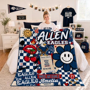 Puede incluir: Una manta a cuadros azules y blancos con las palabras "ALLEN EAGLES" en letras grandes. La manta presenta varios gráficos, incluyendo un sol sonriente, labios, cerezas, una flor y un águila. La manta también tiene el texto "Amelia EAGLES".
