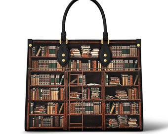 Puede incluir: Un bolso tote de cuero negro con un estampado de librería. El bolso tiene dos asas superiores y detalles dorados. La librería está llena de libros de varios tamaños y colores.