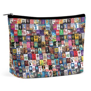 Puede incluir: Un neceser rectangular con cremallera negra y un colorido collage de carteles de espectáculos de Broadway. La bolsa presenta una variedad de títulos de espectáculos y el texto "Name Here" en rojo.