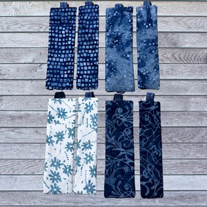 May include: Set of eight blue and white fabric bookmarks with various patterns. The bookmarks are made of cotton fabric and have a simple design.
