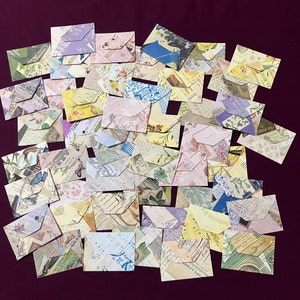 May include: A collection of vintage-style envelopes with various patterns and designs. The envelopes are made of paper and have a distressed look. They are perfect for adding a touch of vintage charm to your crafts or projects.