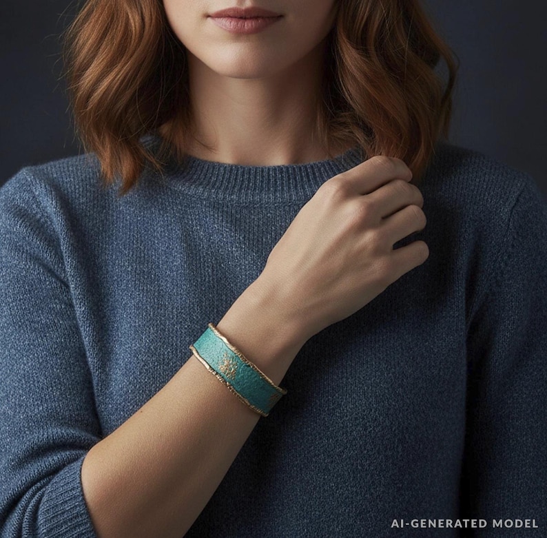 A close-up of a woman wearing a blue sweater and a turquoise bracelet, with her hand resting on her chin.