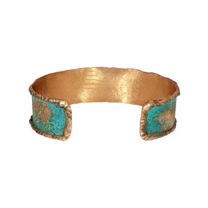 A gold and turquoise cuff bracelet with a textured design.