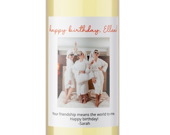 Puede incluir: Una botella de vino transparente con tapón negro y etiqueta blanca. La etiqueta presenta una foto de tres personas con batas blancas y el texto "happy birthday, Ellen!" y "Your friendship means the world to me. Happy birthday! -Sarah."