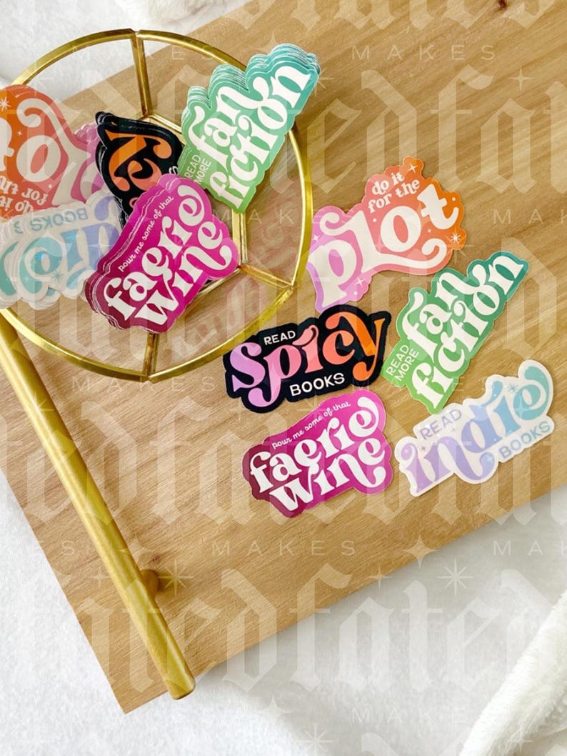 May include: A collection of colorful stickers with book-themed phrases like "pour me some of that faerie wine", "do it for the plot", "read more indie", and "read more spicy".