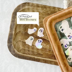 May include: A pack of four iridescent ghost mini stickers on a wooden tray. The sticker pack label reads "4 Pack of Mini Stickers".