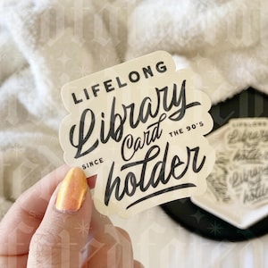 May include: A white sticker with black text that reads "Lifelong Library Card holder since the 90's".