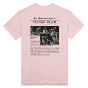 A Ferrari Newspaper-style graphic design at the back of the t-shirt, with the words Ferrari Flair at the back of the merchandise. Printed on a pink colored T-shirt.