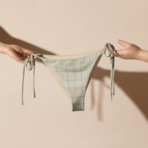 May include: A light green and white plaid bikini bottom with tie sides.