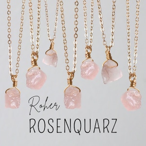 Puede incluir: Siete collares de oro con colgantes de cuarzo rosa en bruto. Los collares están sobre un fondo blanco. El texto "Roher ROSENQUARZ" está en la parte inferior de la imagen.