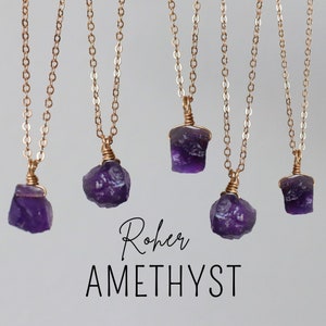 Könnte beinhalten: Fünf Amethyst-Halsketten mit goldfarbenen Ketten und drahtumwickelten Anhängern. Die rohen Amethyststeine sind tiefviolett. Das Bild enthält den Text "Roher AMETHYST".