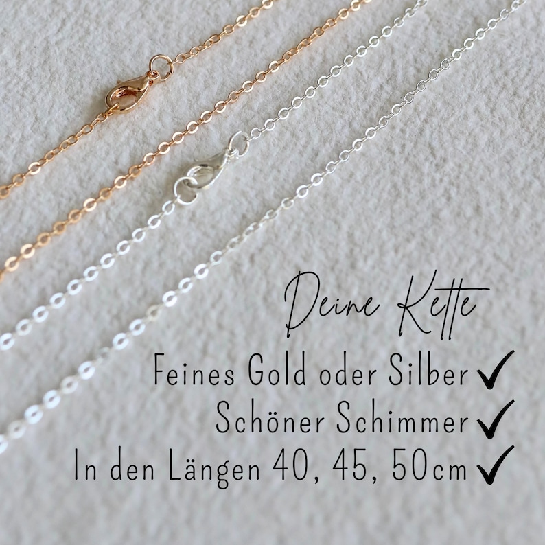May include: Two delicate chains, one gold and one silver, lie on a textured surface. The chains are shown in different lengths, with checkmarks indicating available sizes: 40, 45, and 50 centimetres. The text "Deine Kette" is written in cursive above the chains.