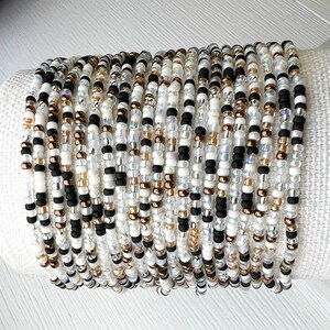 Glass Bead Bracelet Tiny Seed Design Neutral Color Palette Dainty Minimalist Jewelry Comfortable Elastic Band Perfect Everyday Accessory Thin Delicate Style Layering Essential Casual Outfit Complement Versatile Wrist Piece Multiple Sizes