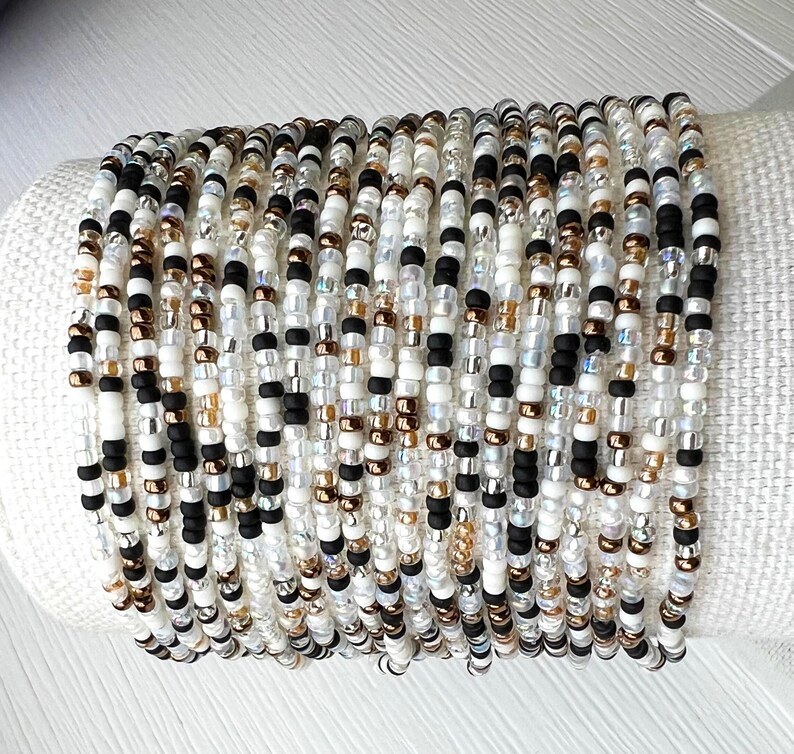 Glass Bead Bracelet Tiny Seed Design Neutral Color Palette Dainty Minimalist Jewelry Comfortable Elastic Band Perfect Everyday Accessory Thin Delicate Style Layering Essential Casual Outfit Complement Versatile Wrist Piece Multiple Sizes