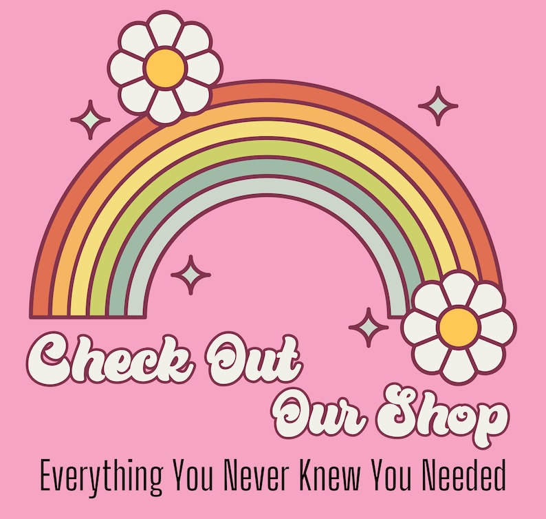May include: A rainbow with white daisies on either side, on a pink background. The text "Check Out Our Shop" is written in a retro font, with the tagline "Everything You Never Knew You Needed" below.