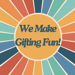 May include: A graphic design featuring a central mustard yellow circle with the dark blue text "We Make Gifting Fun!" surrounded by radiating sunburst stripes in alternating colors of light blue, teal, orange, red, and yellow.