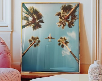 Könnte beinhalten: Ein gerahmter Druck eines blauen Himmels mit Palmen und einem kleinen Flugzeug, das darüber fliegt.
