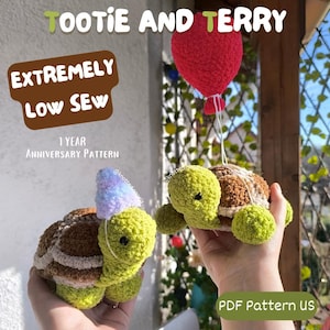 May include: Two crocheted turtle amigurumi toys, one brown and one green, with a red balloon. The green turtle is wearing a purple and blue party hat. The text "TOOTIE AND TERRY EXTREMELY LOW SEW 1 YEAR ANNIVERSARY PATTERN PDF Pattern US" is visible in the image.