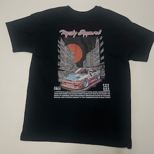 May include: Black t-shirt with a graphic print of a blue car driving through a city street at night. The graphic also includes a red sun and the text "Mysty Apparel" and "2024". The text below the graphic reads "A notorious illegal racing team based in Tokyo, Japan, renowned for their high-speed and daring street races that take place under the cover of darkness. They have gained a reputation as one of the most skilled and elusive groups in the underground racing scene."