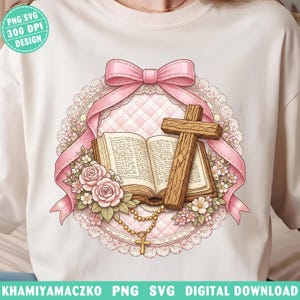 May include: White t-shirt featuring a religious design. The design includes an open book, a wooden cross, pink roses, and a rosary. A pink ribbon and lace frame the central elements. The text "PNG SVG 300 DPI DESIGN" is in the upper left corner.