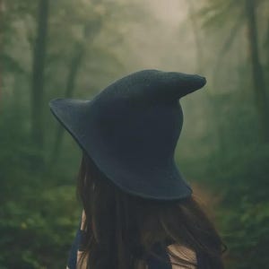 May include: A dark charcoal grey felt hat with a tall, pointed crown and a wide, slightly curved brim. The hat features a structured, conical shape that tapers to a rounded tip, crafted from a solid, matte-textured material in a deep, neutral tone.