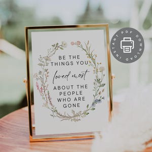 May include: Printable sign with a floral wreath design. The text reads "Be the things you loved most about the people who are gone."