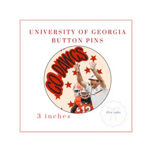 Puede incluir: Un pin de botón de 7,6 cm de diámetro con un diseño rojo y blanco con las palabras "Go Dawgs" en negro. El pin también presenta una foto de un entrenador de fútbol y un jugador celebrando.