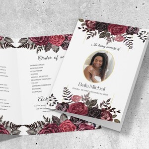 May include: A white memorial program with a photo of a woman, surrounded by burgundy and black floral arrangements. The text includes "Obituary", "Order of Service", and "In loving memory of Bella Mitchell". The Canva logo is visible.
