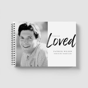 May include: A monochrome photo album with a portrait of a smiling person on the left page. The right page displays the words "Forever Loved" and the name and dates "Patrick Wilson, October 03, 1960 - December 12, 2026."