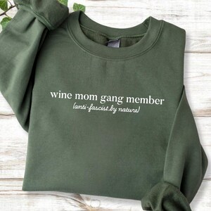 A green sweatshirt with white text printed on it.